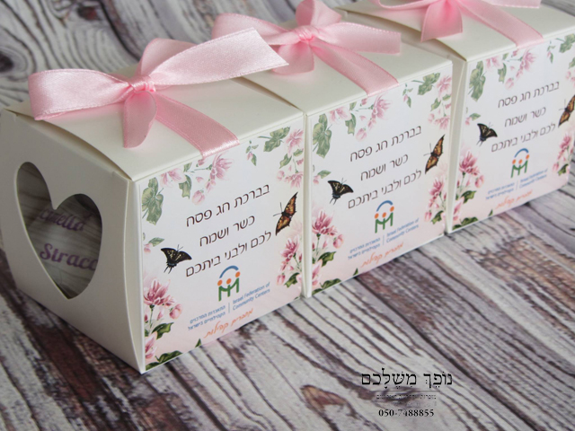 אריזת ריבוע במיתוג אישי ואביבי - שי לפסח אריזת ריבוע במיתוג אישי עם חלון לב שמאפשר הצצה למילוי, ניתן למלא במילוי לפי בחירה - שוקולדים, סוכריות וכו'. האריזה עטופה בסרט סאטן בצבעי המיתוג, האריזה ממותגת באמצעות מדבקה הכוללת לוגו ומסר אישי מהחברה. ניתן לקבל מוצר זה בהדפסה מלאה, בכמות מעל 300 יחידות. כיף לקבל מוצר שכזה שלבטח יגרוף המון מחמאות, מוצר מפנק!